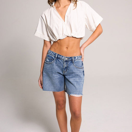 Stylish model showcasing Belle's Baggy Bermuda Short - Medium Indigo, made of 100% cotton for effortless summer wear.