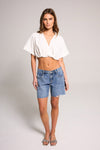 Stylish model showcasing Belle's Baggy Bermuda Short - Medium Indigo, made from 100% cotton for comfort.